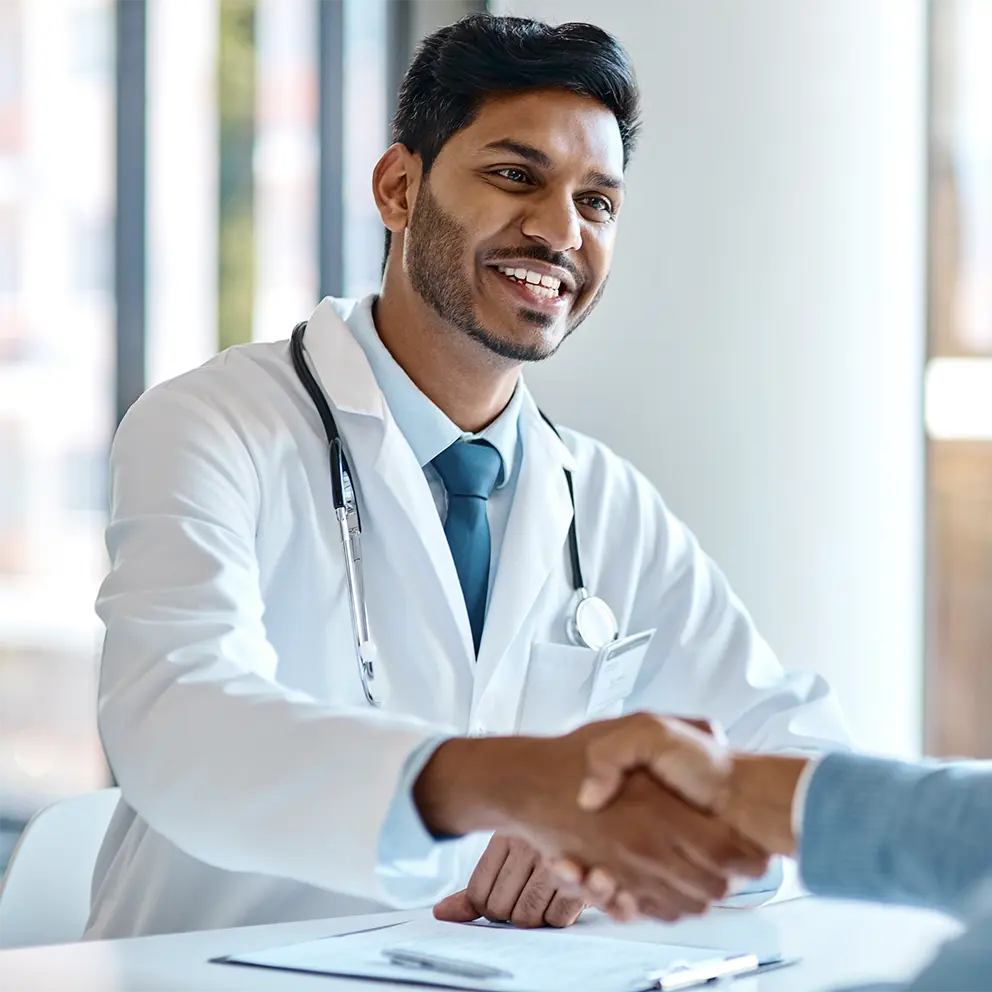doctor shaking hands with business partner during meeting
