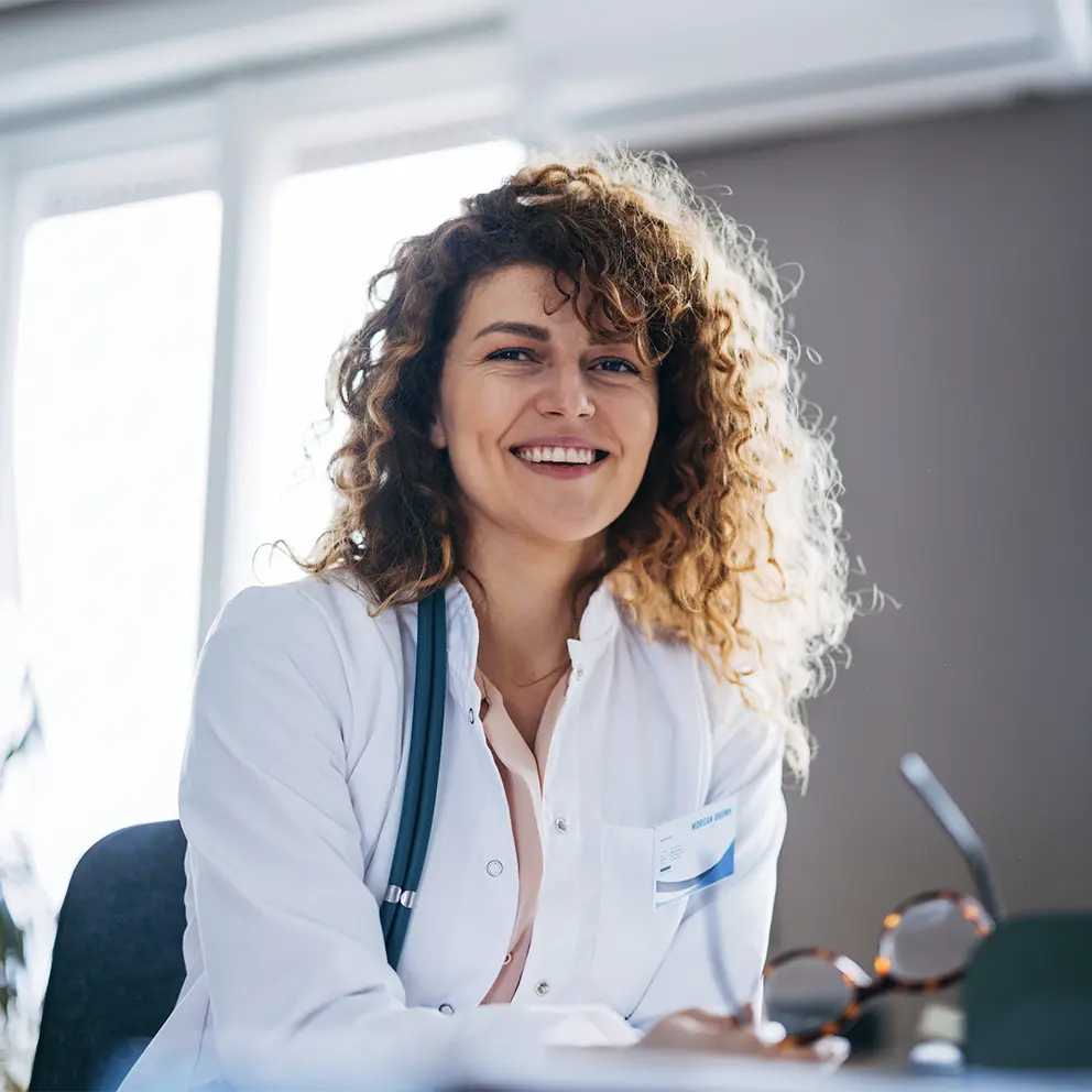 smiling doctor sitting at her desk