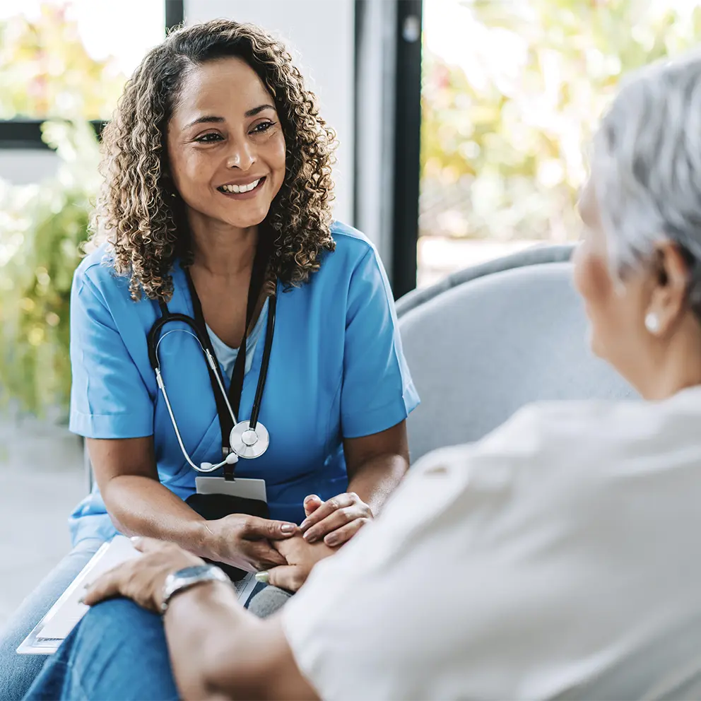 caring nurse consulting with patient at her home