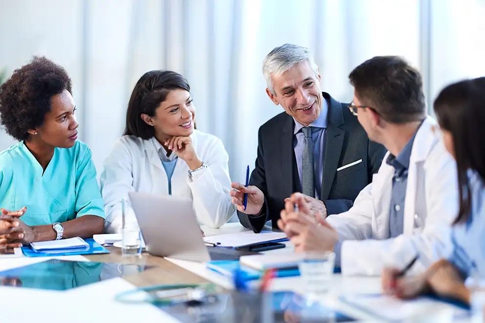 Doctors meeting with businessman at a conference table